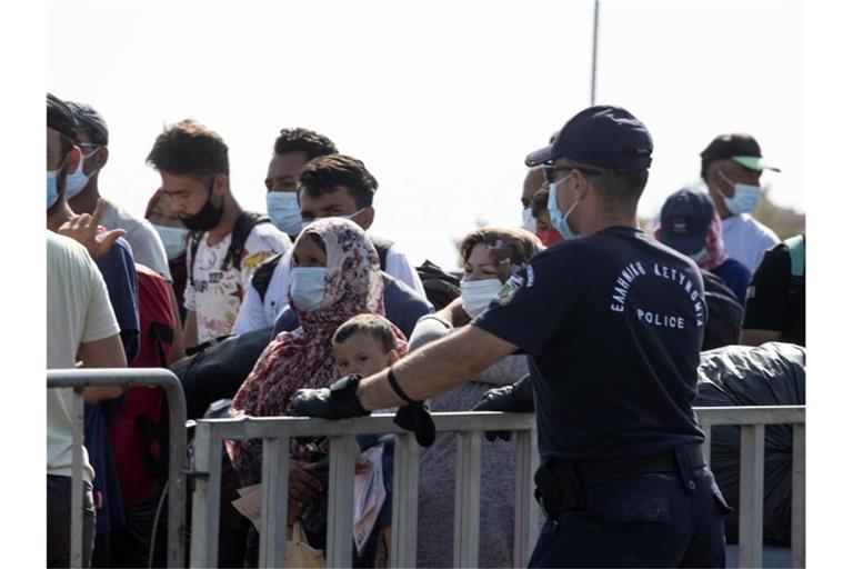 Migranten vor dem Eingang des Lagers Kara Tepe Schlange. Foto: Petros Giannakouris/AP/dpa