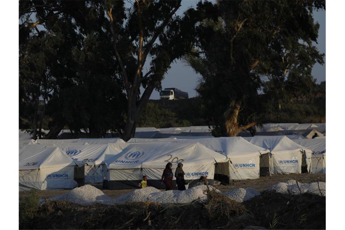 Migranten vor neuen Zelten in einem provisorischen Lager in der Nähe der Inselhauptstadt Mytilini. Foto: Petros Giannakouris/AP/dpa