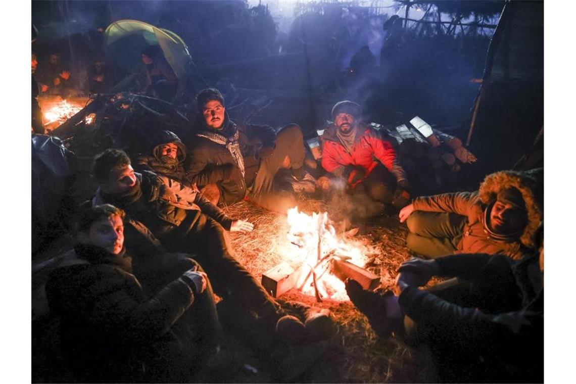 Migranten wärmen sich an einem Feuer an der belarussisch-polnischen Grenze auf. Foto: Oksana Manchuk/BelTA/AP/dpa