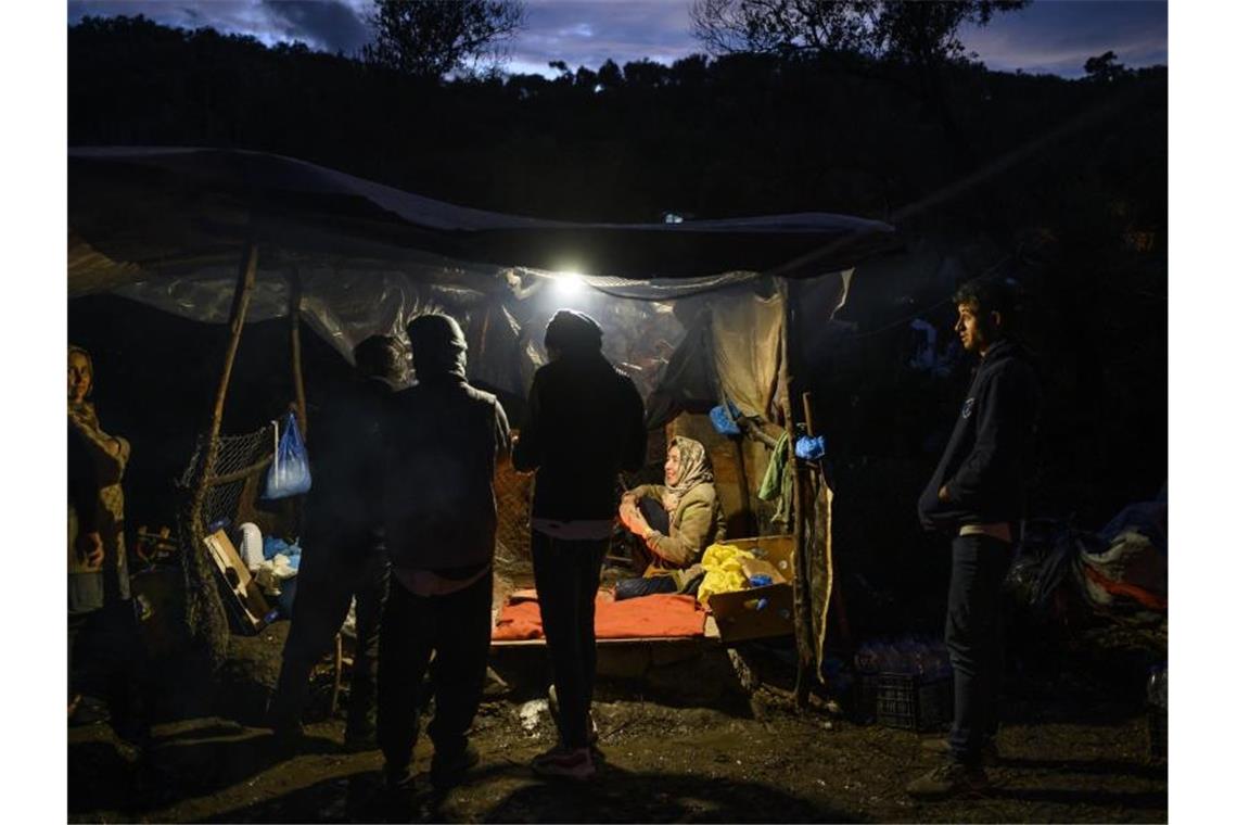 Flüchtlinge im Mittelmeer: Griechenland wieder im Fokus Migranten warten in einem Zwischenlager auf Lesbos darauf, Brot kaufen zu können. Foto: Angelos Tzortzinis/dpa