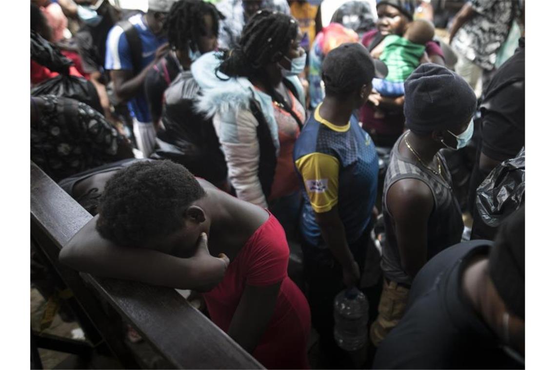 Migranten warten inmitten der Corona-Pandemie auf ein Boot, das sie nach Capurgana an der Grenze zu Panama bringen soll. Foto: Ivan Valencia/AP/dpa
