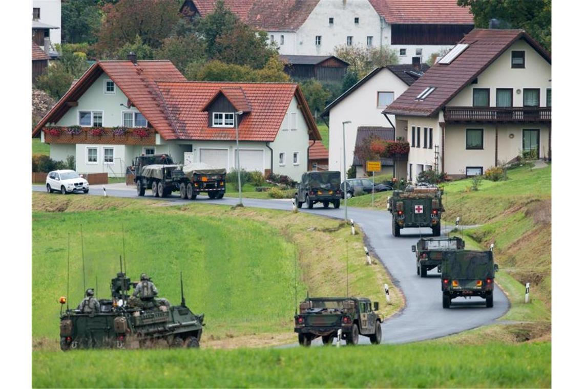 Militärfahrzeuge der US-Armee fahren durch den Ort Kleinfalz nahe dem Truppenübungsplatz Grafenwöhr in Bayern. Foto: Armin Weigel/dpa/Archiv