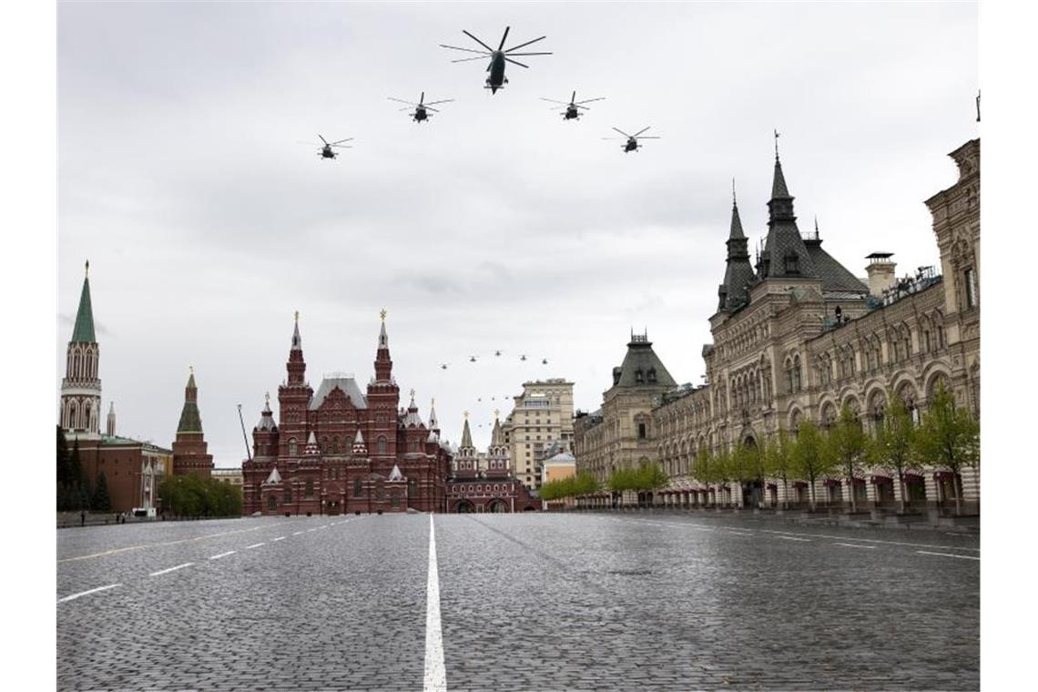 Militärhubschrauber fliegen über den menschenleeren Roten Platz. Foto: Alexander Zemlianichenko/AP/dpa