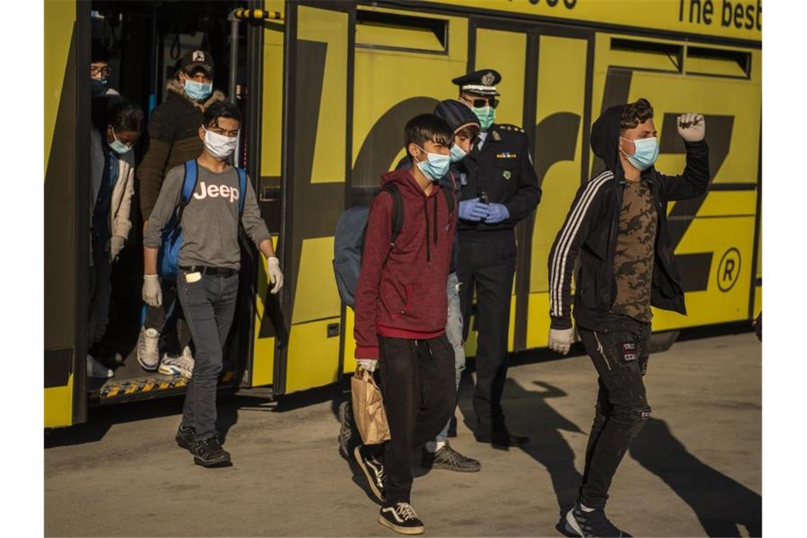 Minderjährige Flüchtlinge von griechischen Inseln gehen am Athener Flughafen zu einem Flugzeug, das sie nach Hannover bringen soll. Foto: Angelos Tzortzinis/dpa