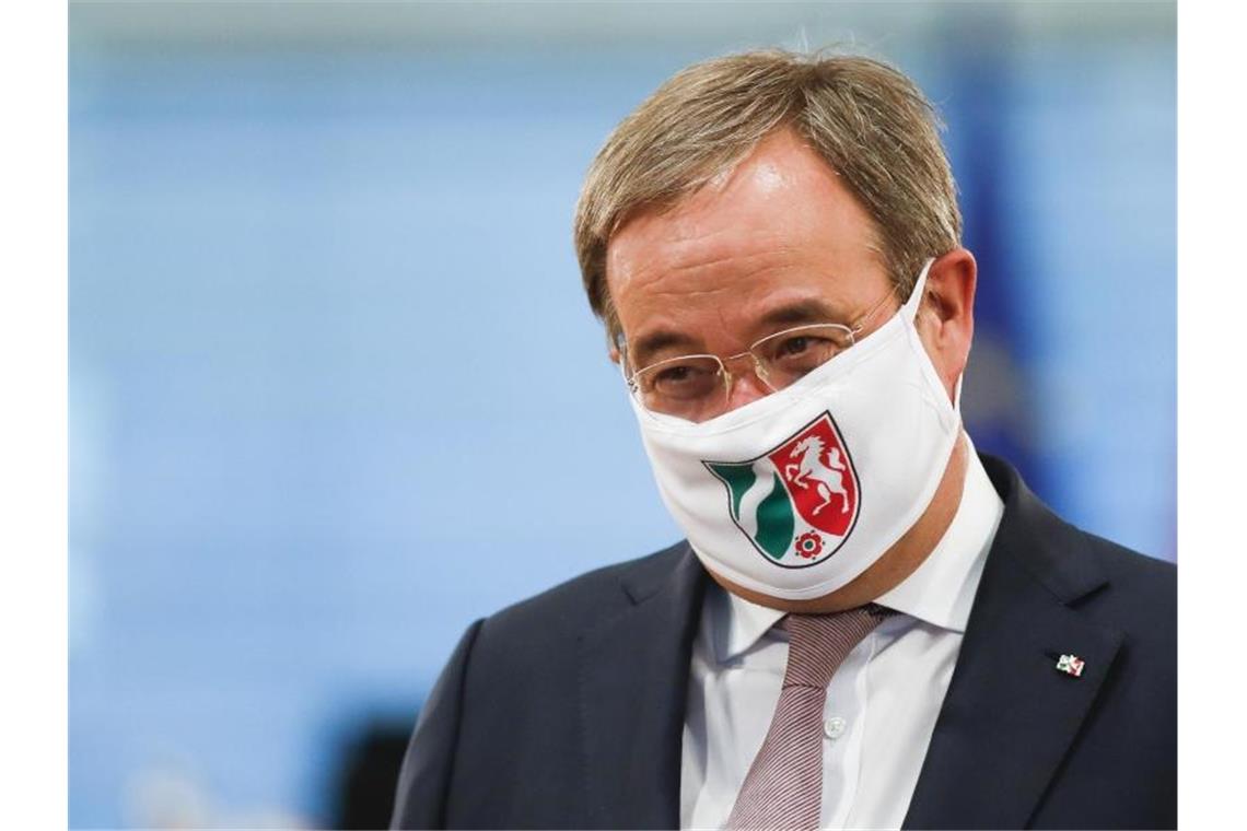 Ministerpräsident Armin Laschet mit einer Gesichtsmaske mit NRW-Wappen. Foto: Markus Schreiber/AP-Pool/dpa