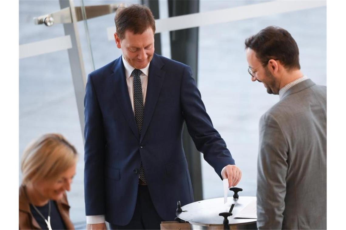 Sachsen-Koalition steht - Kretschmer bleibt Regierungschef Ministerpräsident Michael Kretschmer (M, CDU) gibt seine Stimme ab zur Wahl des Ministerpräsidenten bei der Sitzung des sächsischen Landtags. Foto: Robert Michael/dpa