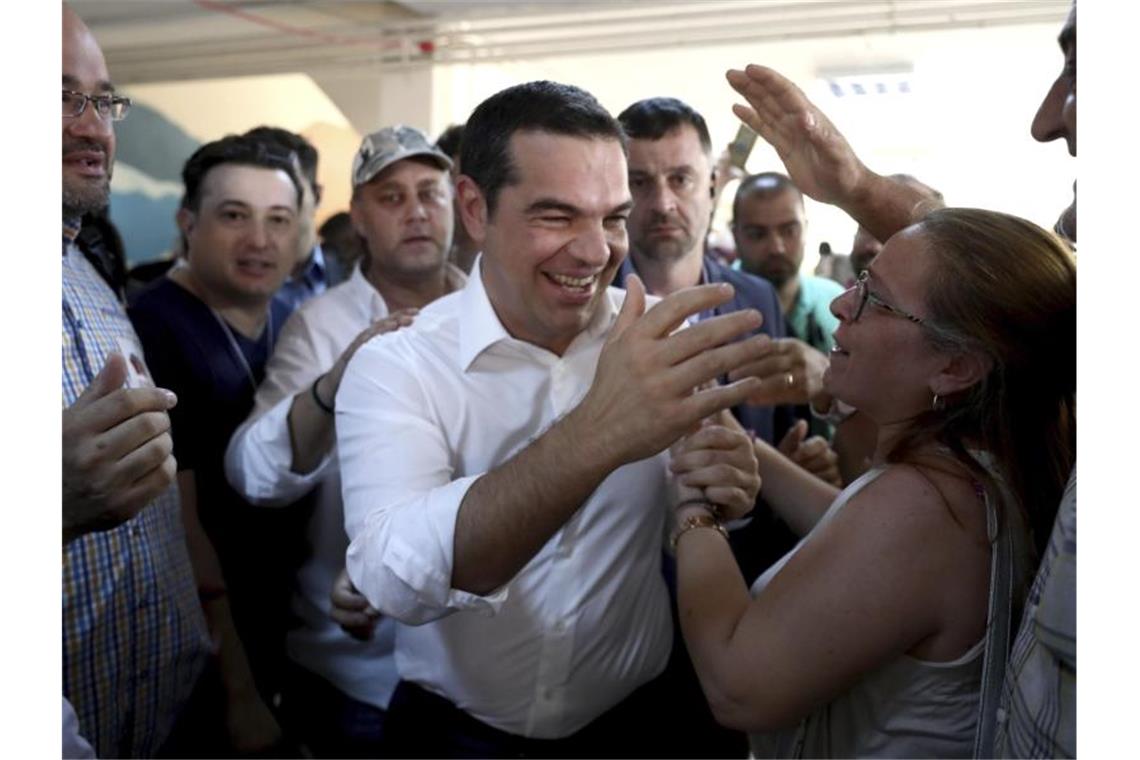 Griechenland wählt Konservative an die Macht Ministerpräsident und Syriza-Chef Alexis Tsipras begrüßt Anhänger vor einem Wahllokal. Foto: Yorgos Karahalis/AP