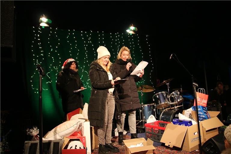 Mirjam Rienth, Olga Tseros und Nadieka Fegert (von rechts) übergeben die Preise der Tombola. Wie alles bei der Steinbacher Fleckaweihnacht stammen diese aus Sachspenden – der Erlös des gesamten Weihnachtsmarkts geht an das Kinderhospiz. Foto: privat