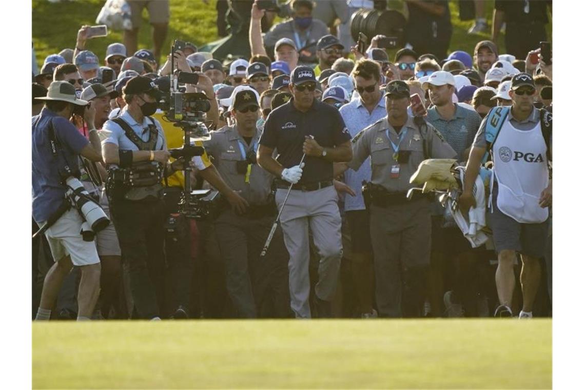 Mit 50 Jahren gewinnt US-Golfstar Phil Mickelson (M) - umgeben von seinen Fans - das Major-Turnier. Foto: Matt York/AP/dpa