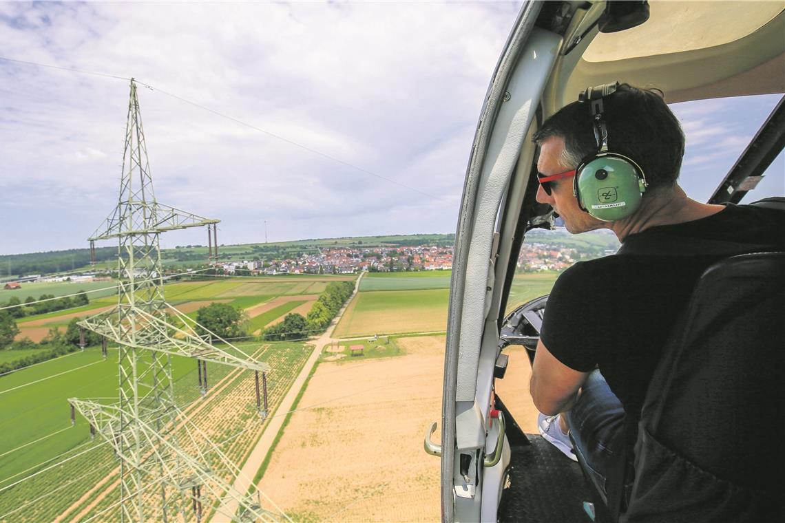 Mit bloßem Augen kontrolliert Bernd Stöhr die Leitungen, während Pilot Marc Fischer die Trasse Meter für Meter abfliegt. Fotos: A. Becher