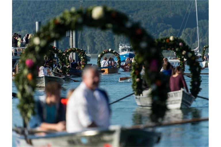 Mit Blumenkränzen geschmückte Boote während der Mooser Wasserprozession. Foto: Patrick Seeger/Archivbild