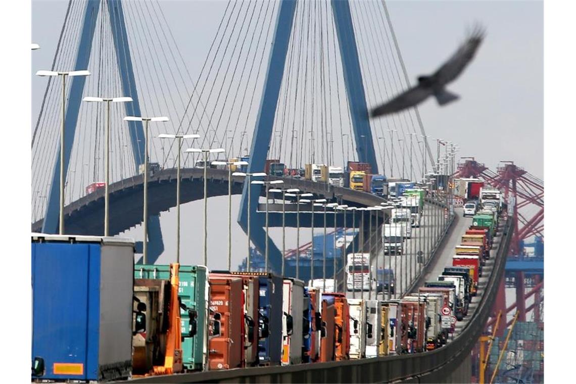 Mit Containern beladene Lastwagen stauen sich auf der Köhlbrandbrücke im Hamburger Hafen: Der Außenhandelsverband BGA hatte jüngst seine Prognose für dieses Jahr nach unten korrigiert. Foto: Christian Charisius/dpa