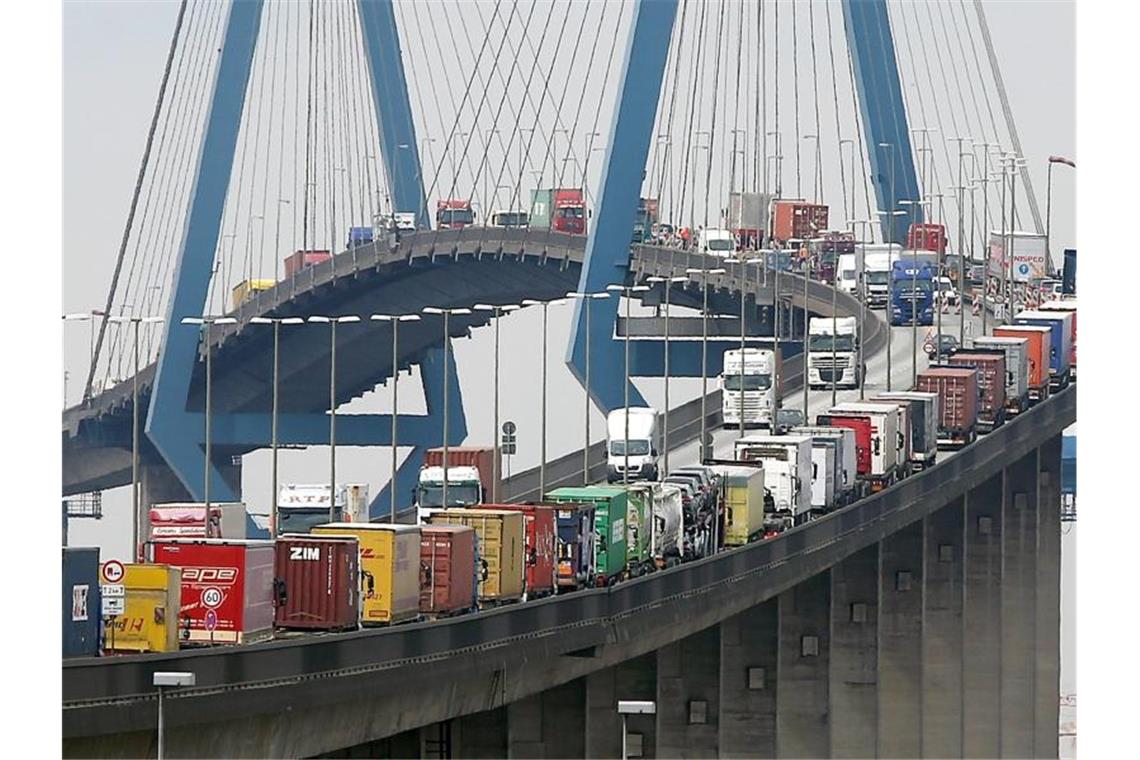 Mit Containern beladene Lastwagen stauen sich auf der Köhlbrandbrücke im Hamburger Hafen. Foto: Christian Charisius/dpa