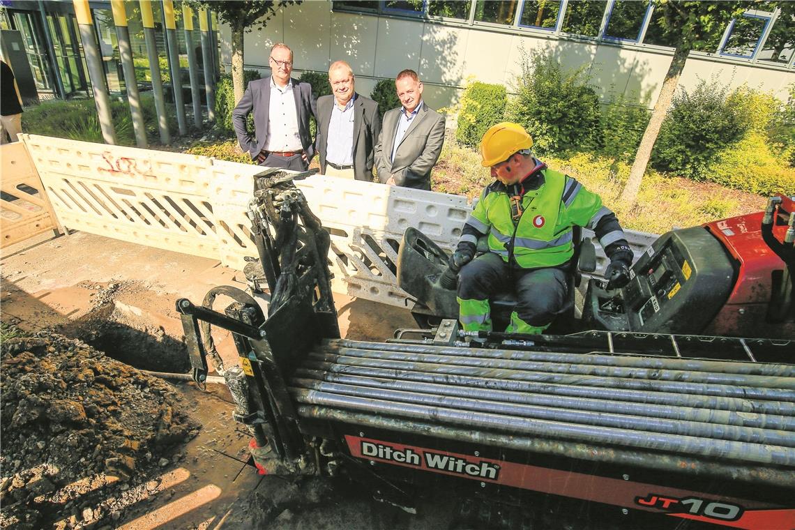 Mit dem Horizontalbohrer werden Glasfaserkabel verlegt, ohne dass die ganze Straße aufgerissen werden muss. Stefan Klieser (Deutsche Glasfaser), der städtische Wirtschaftsbeauftragte Reiner Gauger und Projektleiter Stefan Zipp (von links) sind mit dem Fortschritt der Bauarbeiten zufrieden. Foto: A. Becher