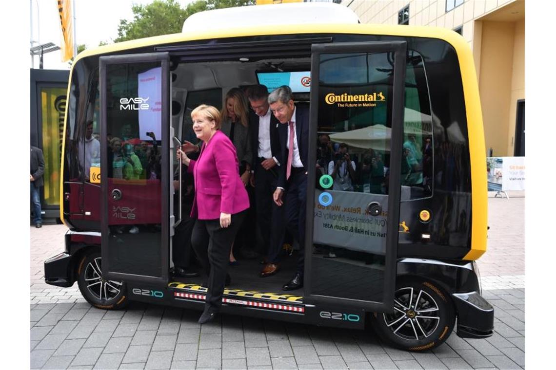 Merkel gibt auf der IAA die E-Kanzlerin Mit dem Robo-Taxi da: Angela Merkel bei ihrem Eröffnungsrundgang auf der IAA neben Bernhard Mattes, Präsident des Verbands der Automobilindustrie. Foto: Boris Roessler