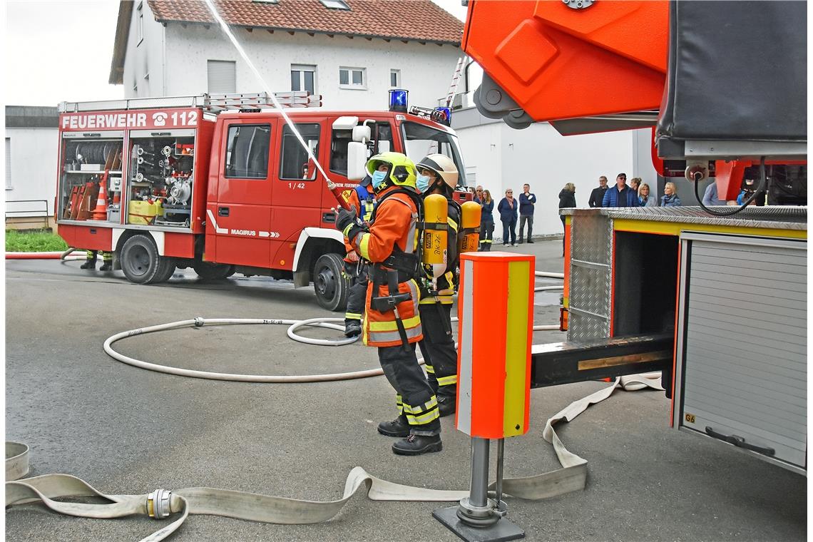 Mit dem Wasserschlauch wird die Fassade eines Nebengebäudes gekühlt, um ein Über...