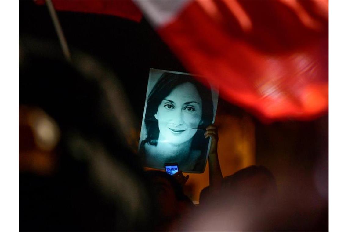 Mit einem Bild der ermordeten Reporterin Daphne Caruana Galizia haben sich Demonstranten vor dem Büro des maltesischen Premierministers postiert. Foto: Str/AP/dpa