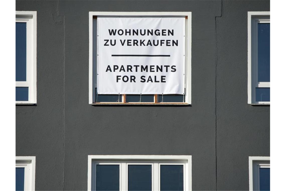 Geteilte Provision: Neues Gesetz entlastet Immobilienkäufer Mit einem großen Plakat werden Wohnungen zum Kauf angeboten. Weniger Maklerkosten entlasten Immobilienkäufer vor allem in Städten, wo Häuser und Wohnungen sehr teuer sind. Foto: Andrea Warnecke/dpa