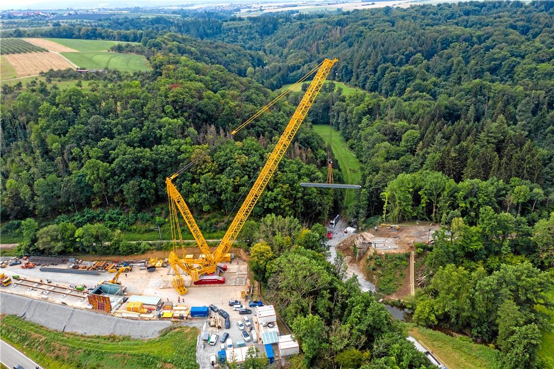 Ersatzbrücke entschwebt am Haken Mit einem neuen Liebherr Raupenkran mit 1000 Tonnen Hubkraft wurden die Eisenbahn-Hilfsbrücken (je 25 Tonnen) über den Buchenbach entfernt. Die Einzelteile der Behelfsbrücke werden im Bahn-Hilfsbrückenzentrum Konz gewartet und bei weiteren Baustellen wieder eingesetzt.Foto: B. Beytekin