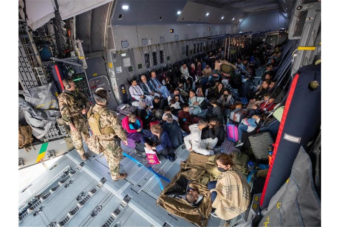 Mit einem Transportflugzeug der Bundeswehr aus Kabul evakuierte Menschen nach der Landung in Taschkent. Foto: Marc Tessensohn/Bundeswehr/dpa