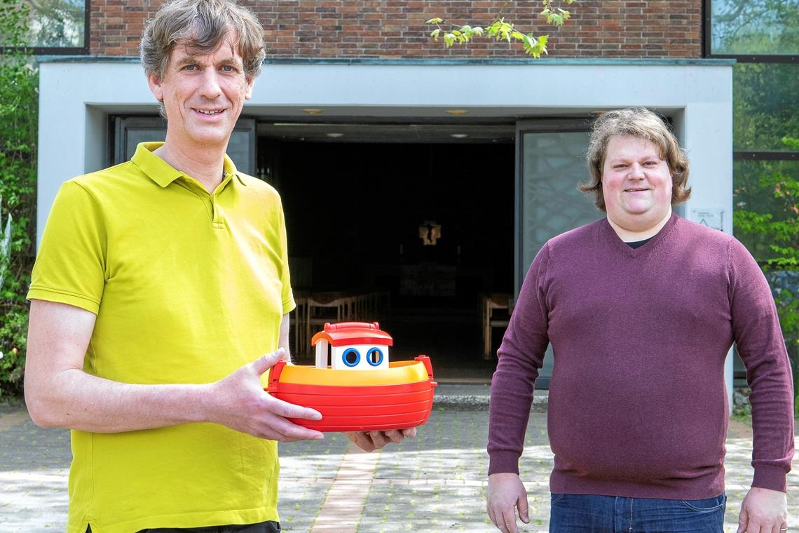 Mit einem zur Spardose umgebauten Spielzeugboot sammeln Tillmann Schamal und Pfarrer Tobias Weimer an der Backnanger Matthäuskirche Spenden für die Seenotrettung. Foto: A. Becher