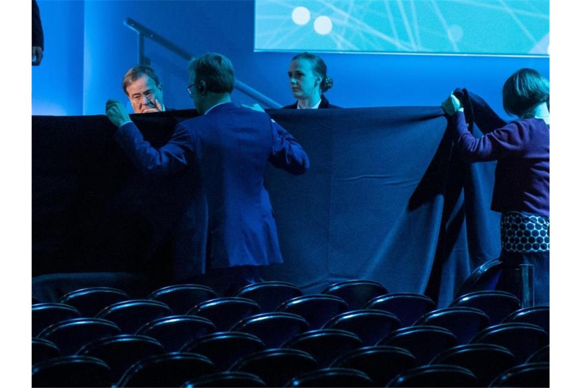 Mit einer Decke wird die Bühne abgeschirmt, auf der Wirtschaftsminister Peter Altmaier beim Digital-Gipfel schwer gestürzt ist. Foto: Bernd Thissen/dpa