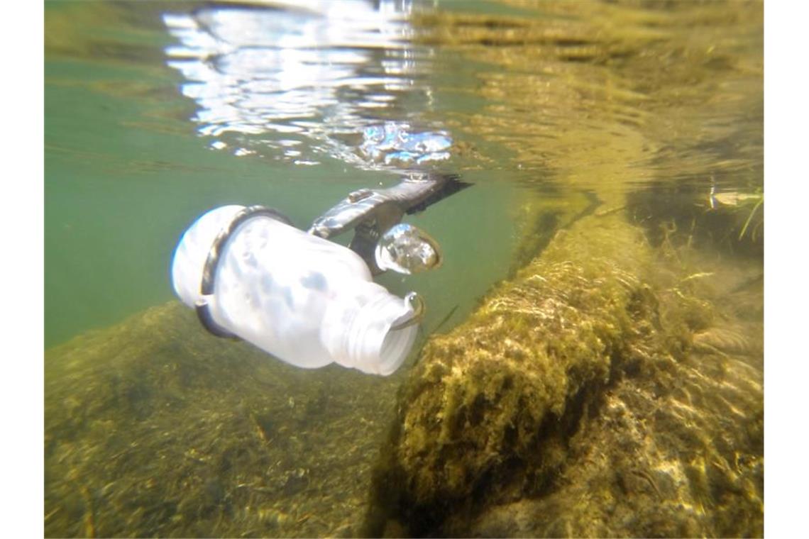 Gesundheitsminister Lucha: Wasserqualität in Badeseen gut Mit einer Kunststoffflasche entnimmt ein Mitarbeiter eine Wasserprobe. Foto: Julian Stratenschulte/Archivbild