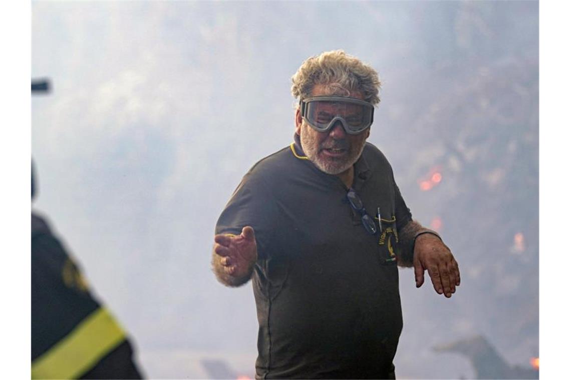 Im Westen Sardiniens wüten weiter die Flammen Mit einer Maske schützt ein Feuerwehrmann seine Augen vor der Hitze und dem Rauch. Foto: Alessandro Tocco/LaPresse via AP/dpa