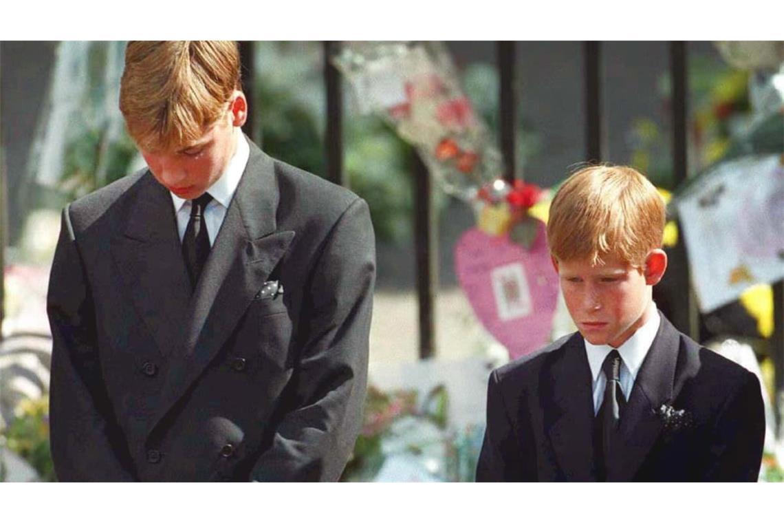 Mit gesenktem Köpfen verfolgen Prinz William (l) und Prinz Harry wie der Sarg mit den sterblichen Überresten ihrer Mutter nach der Trauerfeier am 06.09.1997 aus der Londoner Westminister Abtei getragen wird.