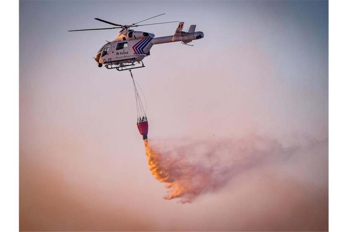 Mit Hilfe eines Hubschraubers wird aus der Luft versucht, das Feuer in dem Naturschutzgebiet „De Liereman“ zu löschen. Foto: Luc Claessen/BELGA/dpa