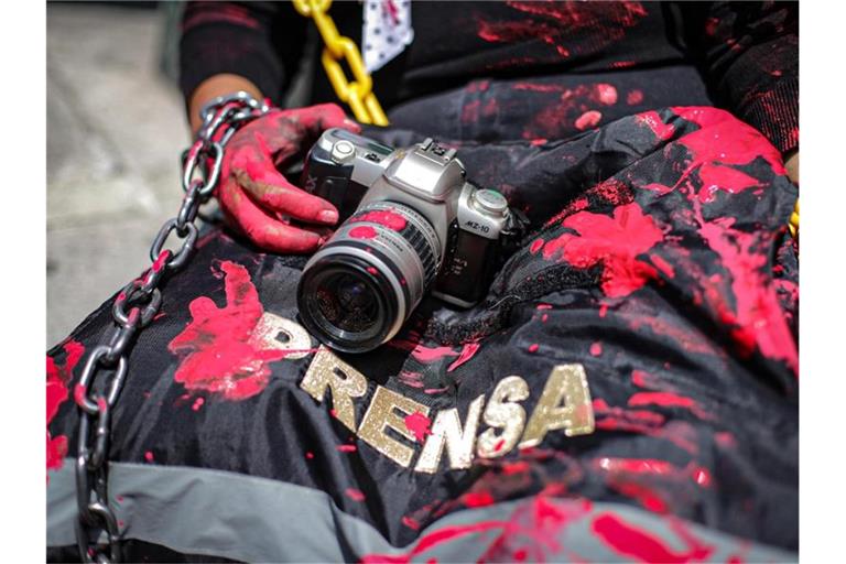 Mit Kamera und rot verschmierter Weste: Mit einer symbolischen Aktion erinnert eine Journalistin in Mexiko an die Ermordung eines Kollegen. Foto: Quetzalli Blanco/NOTIMEX/dpa