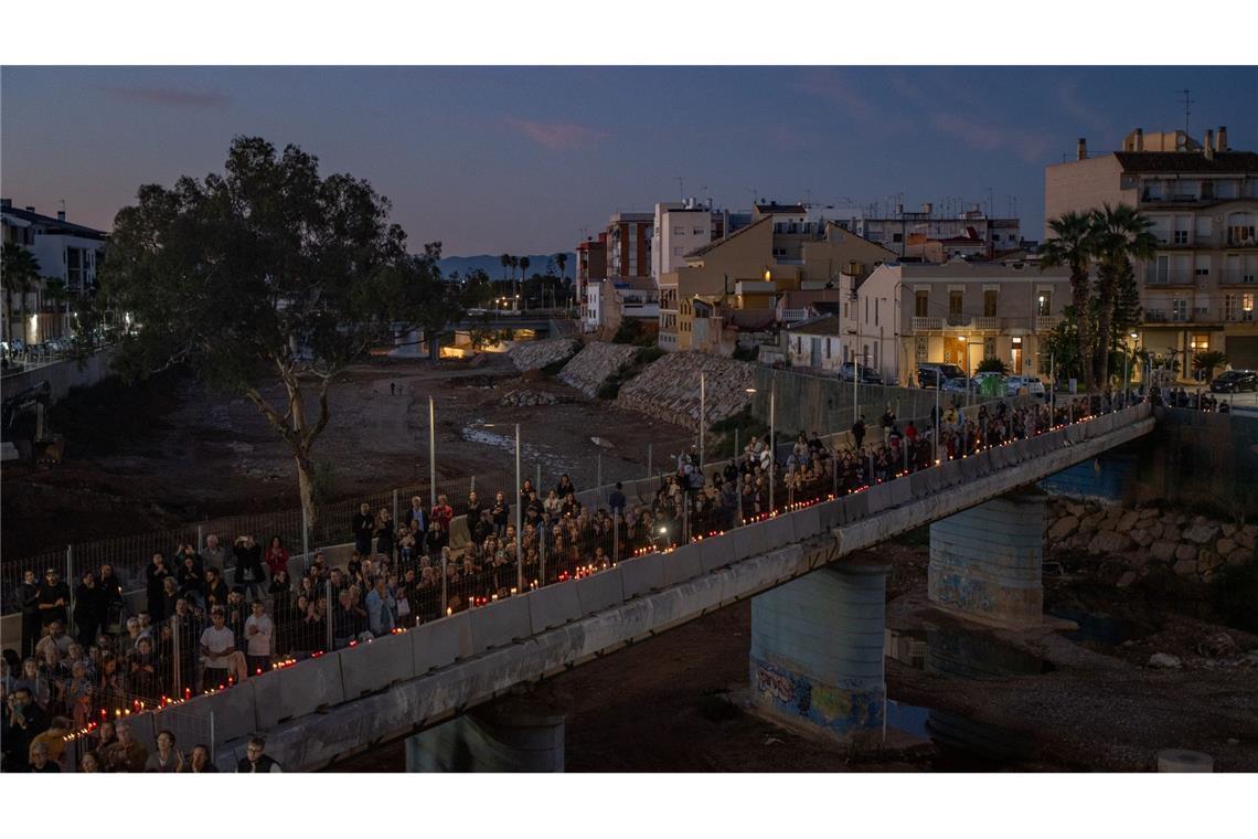 Mit Kerzen in Händen bilden Teilnehmer einer Gedenkveranstaltung eine Menschenkette in Paiporta in der Region Valencia, um an die Opfer der Flutkatastrophe vom Oktober 2024 zu erinnern.