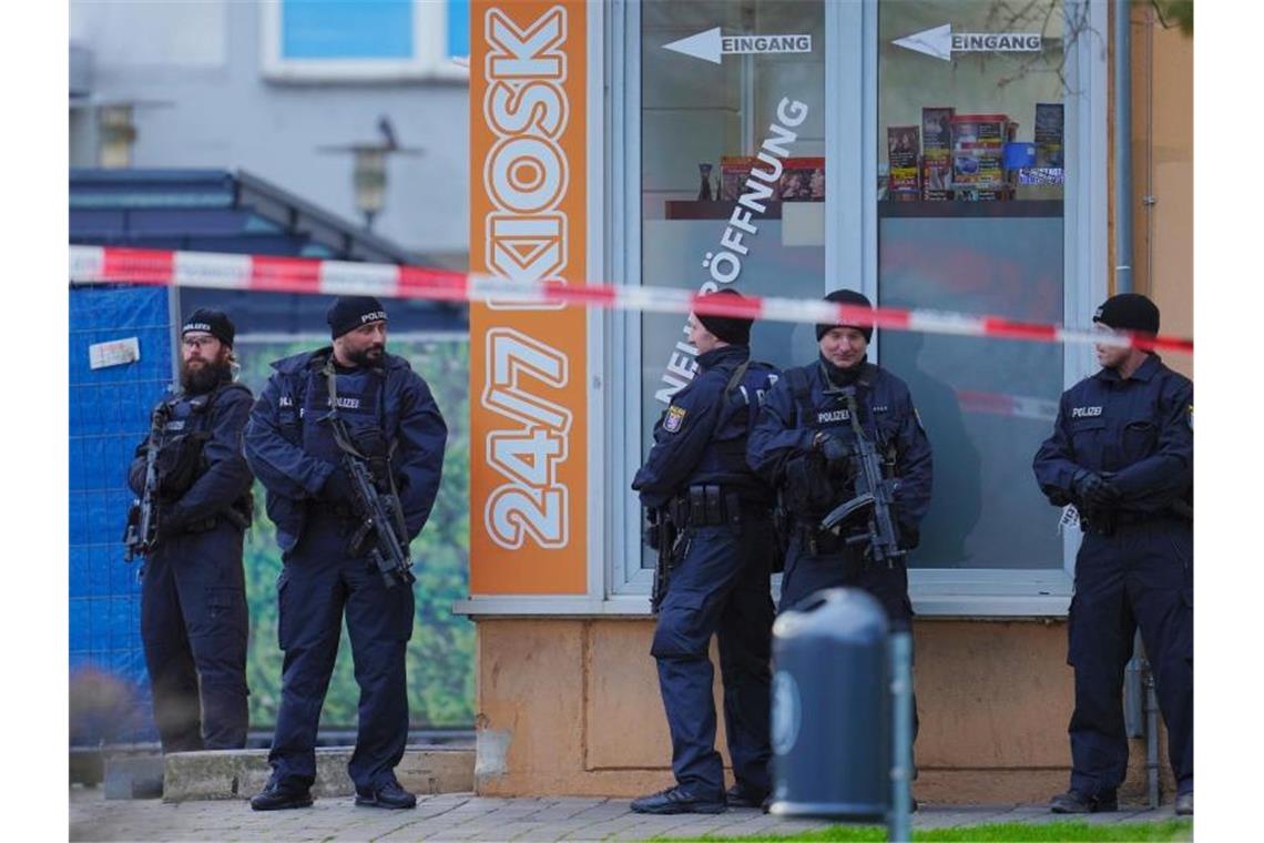 Mit Maschinenpistolen bewaffnete Einsatzkräfte der Polizei vor einem Kiosk am Tatort in Hanau-Kesselstadt. Foto: Uwe Anspach/dpa