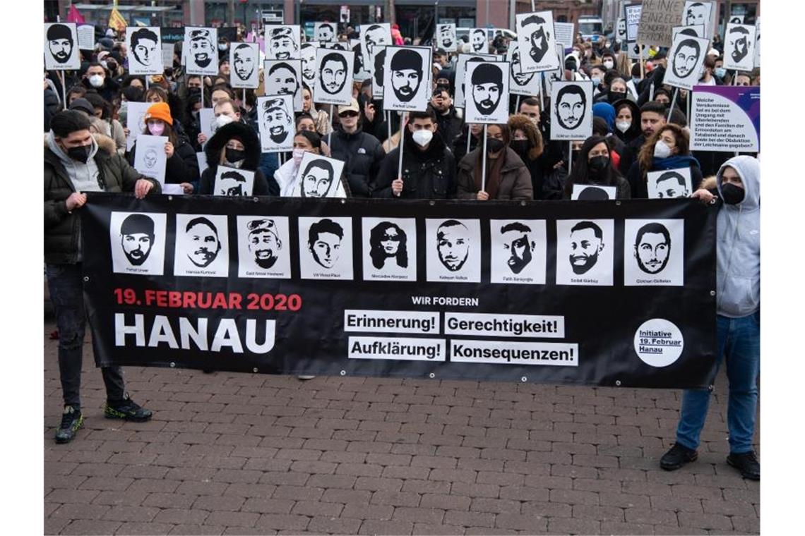 Anschlag in Hanau: „Kein Vergeben - kein Vergessen“ Mit Plakaten und Bildern der Ermordeten erinnern Teilnehmer einer Gedenkveranstaltung auf dem Marktplatz von Hanau an die Opfer der Anschläge von Hanau. Foto: Boris Roessler/dpa