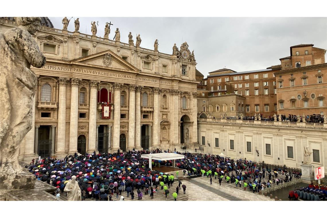 Mit Regencapes und unter Regenschirmen verfolgten die Gläubingen die Ansprache des Papstes.