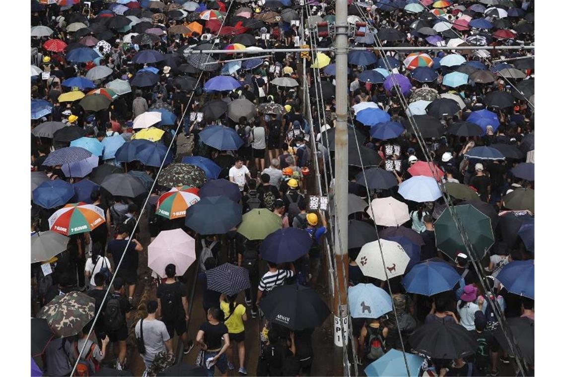 Mit Regenschirmen protestieren Hongkonger gegen die Regierung und einen Angriff von Schlägertrupps eine Woche zuvor. Foto: Vincent Yu/AP