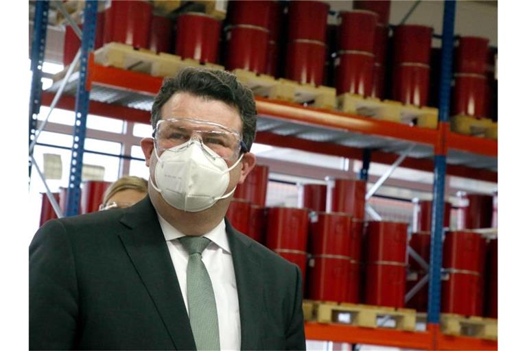 Mit Sicherheitsbrille und Mund-Nasenschutzmaske informiert sich Hubertus Heil (SPD), Bundesarbeitsminister, bei einem Besuch des Unternehmens Gleitsmann Security Inks über Arbeitsschutz und Arbeit unter Coronabedingungen. Foto: Wolfgang Kumm/dpa