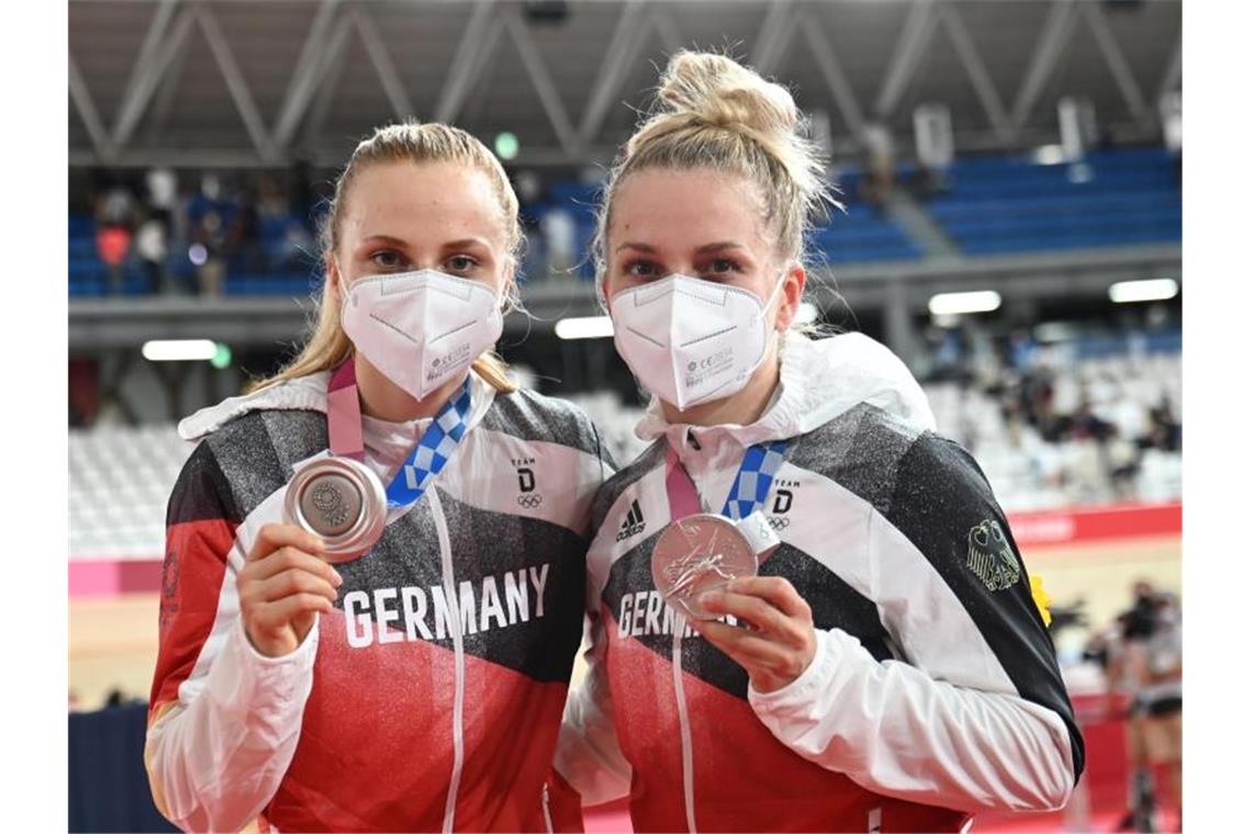 Hinze und Friedrich rasen zu Silber - Vierer mit Weltrekord Mit Silber und Maske: Lea Sophie Friedrich (r) und Emma Hinze präsentieren ihre Medaillen. Foto: Sebastian Gollnow/dpa