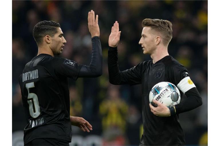 Mit Spielfreude zum höchsten Saisonsieg: Dortmunds Marco Reus (l) klatscht mit Achraf Hakimi nach einem Treffer ab. Foto: Bernd Thissen/dpa