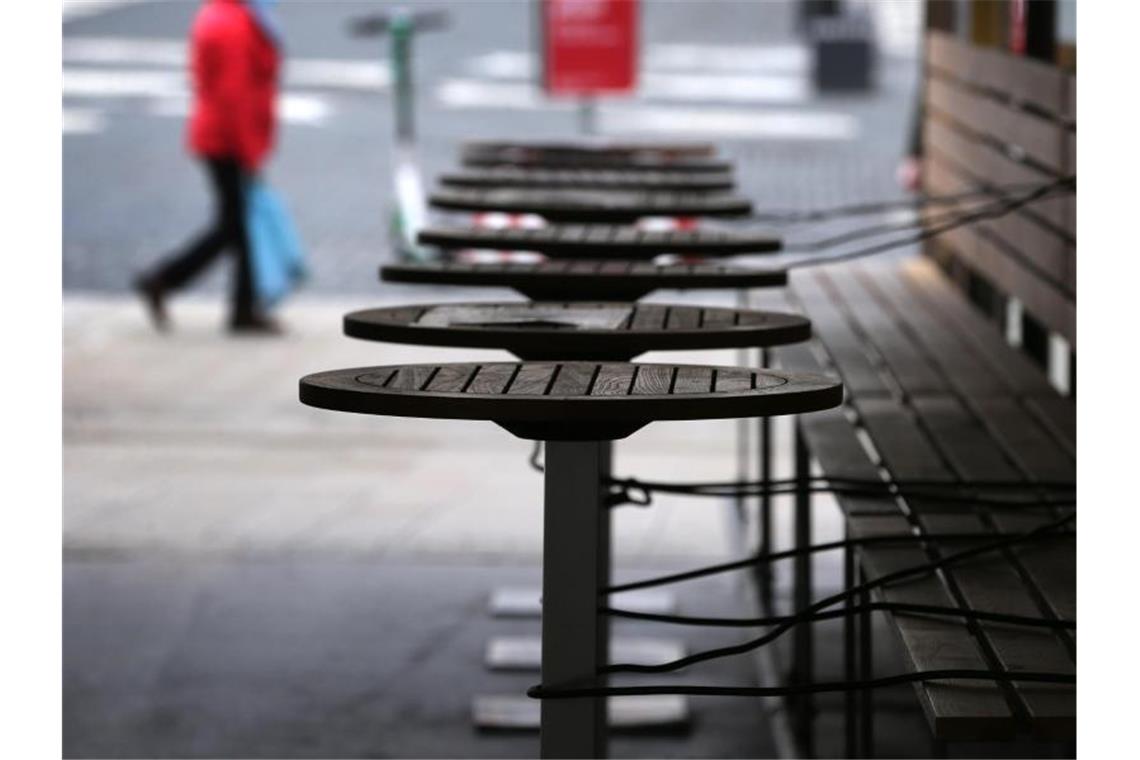 Mit Stahlschnüren gesichert sind die Tische eines wegen der Corona-Beschränkungen geschlossenen Restaurants in Augsburg. Foto: Karl-Josef Hildenbrand/dpa