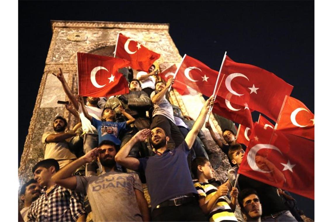 Gedenken an Putschversuch in der Türkei vor drei Jahren Mit türkischen Flaggen in der Hand salutieren Erdogan-Anhänger einen Tag nach dem Putschversuch in Istanbul. Foto: Sedat Suna