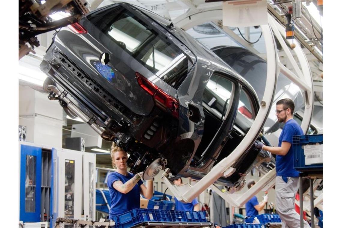 Mitarbeiter arbeiten im Hauptwerk in Wolfsburg im Oktober 2019 an einem Golf 8. Foto: Julian Stratenschulte/dpa