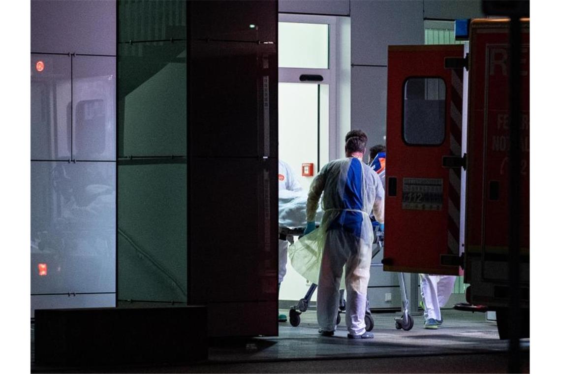 Coronavirus breitet sich in Deutschland aus Mitarbeiter aus dem Leber- und Infektionszentrum des Universitätsklinikums in Düsseldorf nehmen den ersten mit dem Coronavirus Infizierten in NRW in Empfang. Foto: Guido Kirchner/dpa