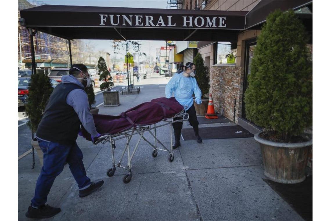 Mitarbeiter bringen eine Leiche in ein Bestattungsinstitut im New Yorker Stadtteil Brooklyn. Foto: John Minchillo/AP/dpa