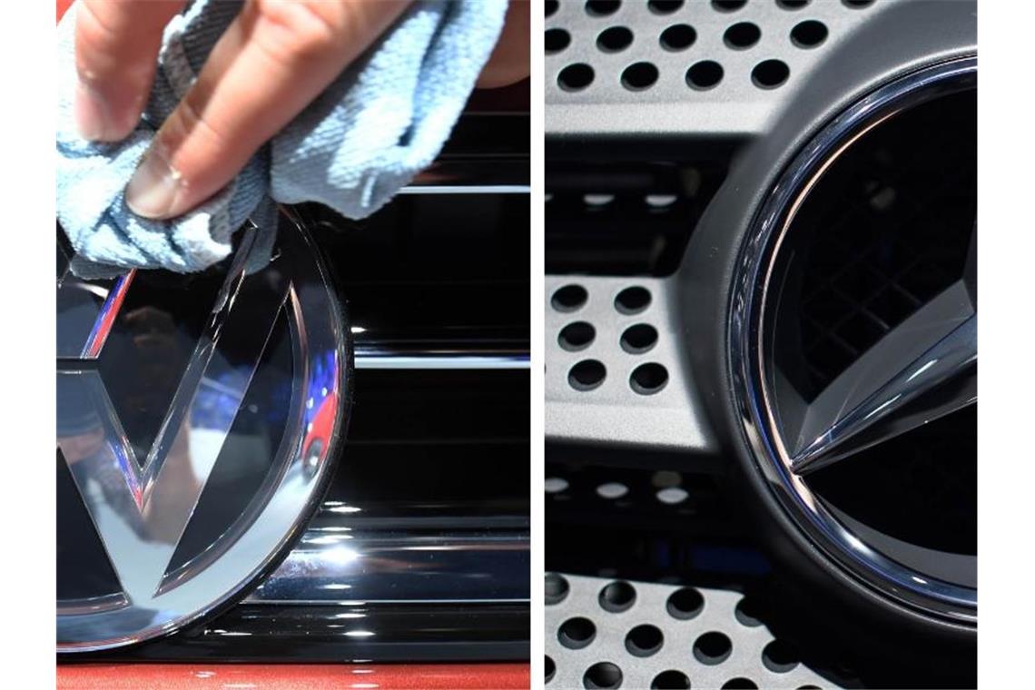 Mitarbeiter der deutschen Automobilmarken BMW Volkswagen (l) und Daimler polieren die Logos der jeweiligen Fahrzeuge. Foto: -/dpa