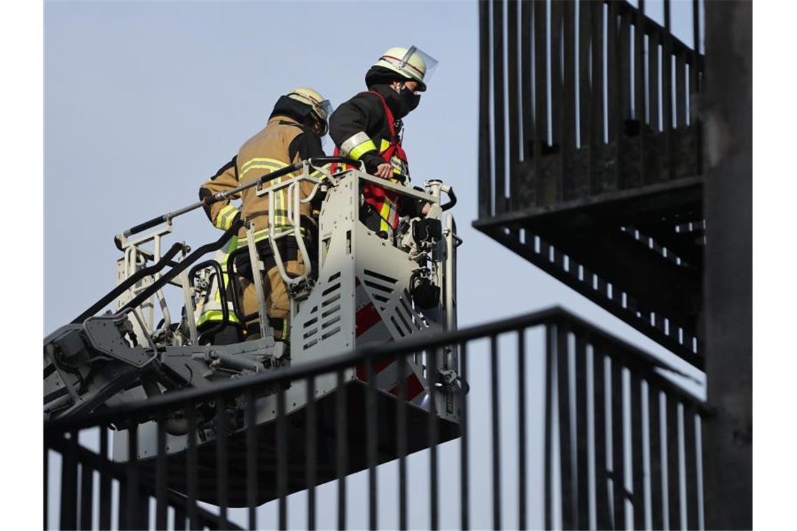 Wohnkomplex in Essen muss nach Großbrand abgerissen werden Mitarbeiter der Feuerwehr begutachten den Schaden am Wohnkomplex in Essen. Foto: David Young/dpa