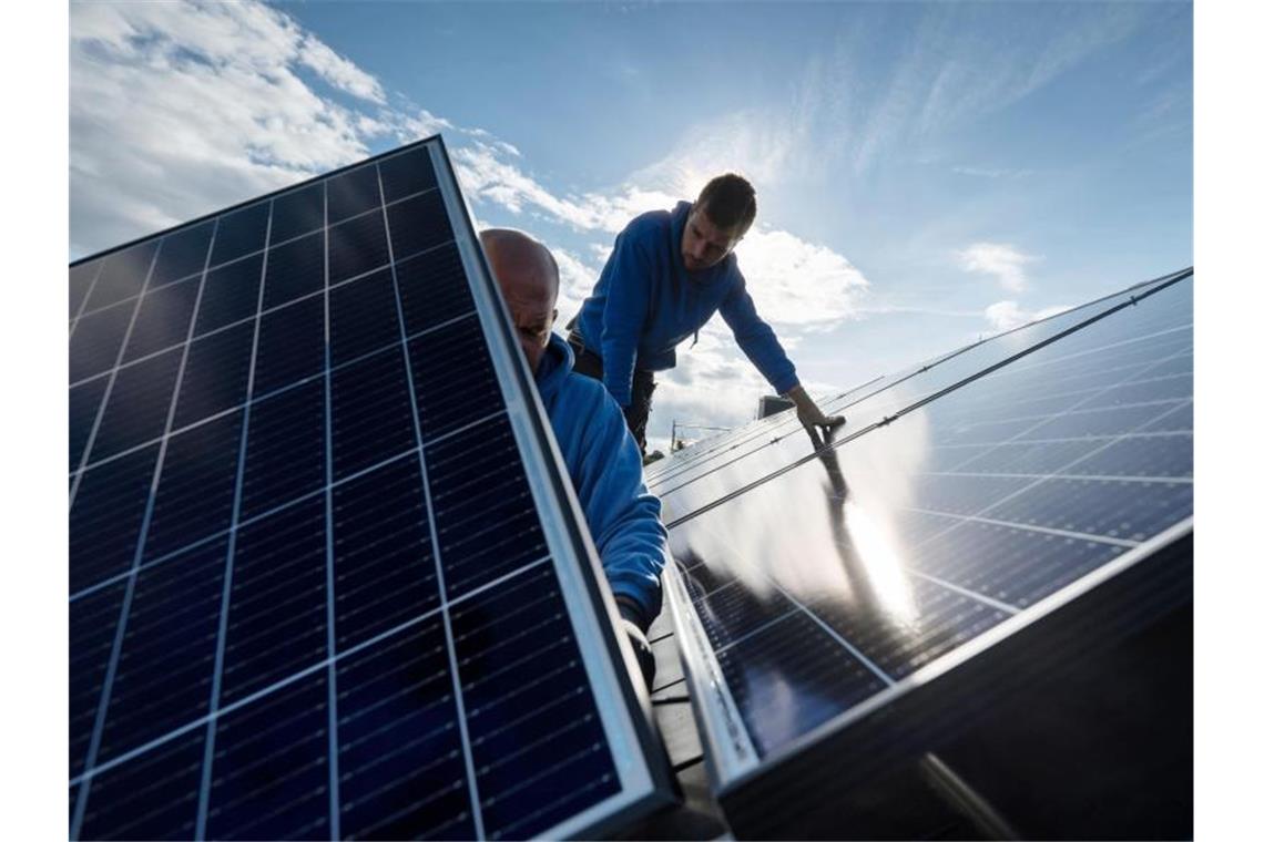 Energie, Pegel, Trockenheit: Daten für Bürger und Kommunen Mitarbeiter der Firma Sontec GmbH montieren Photovoltaikmodule auf dem Dach eines Wohnhauses. Foto: Marijan Murat/dpa/Archivbild