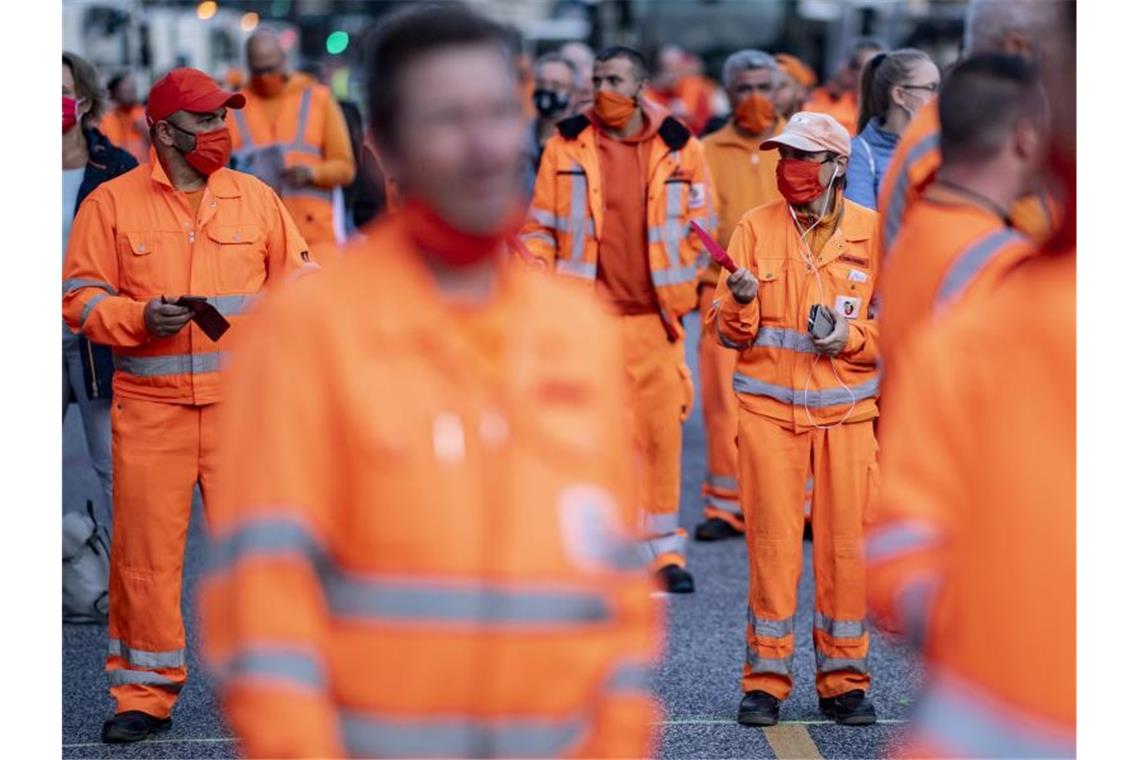 Mitarbeiter der Hamburger Stadtreinigung bei einer Kundgebung der Gewerkschaft Verdi zu Warnstreiks im öffentlichen Dienst auf dem Jungfernstieg in Hamburg. Foto: Axel Heimken/dpa