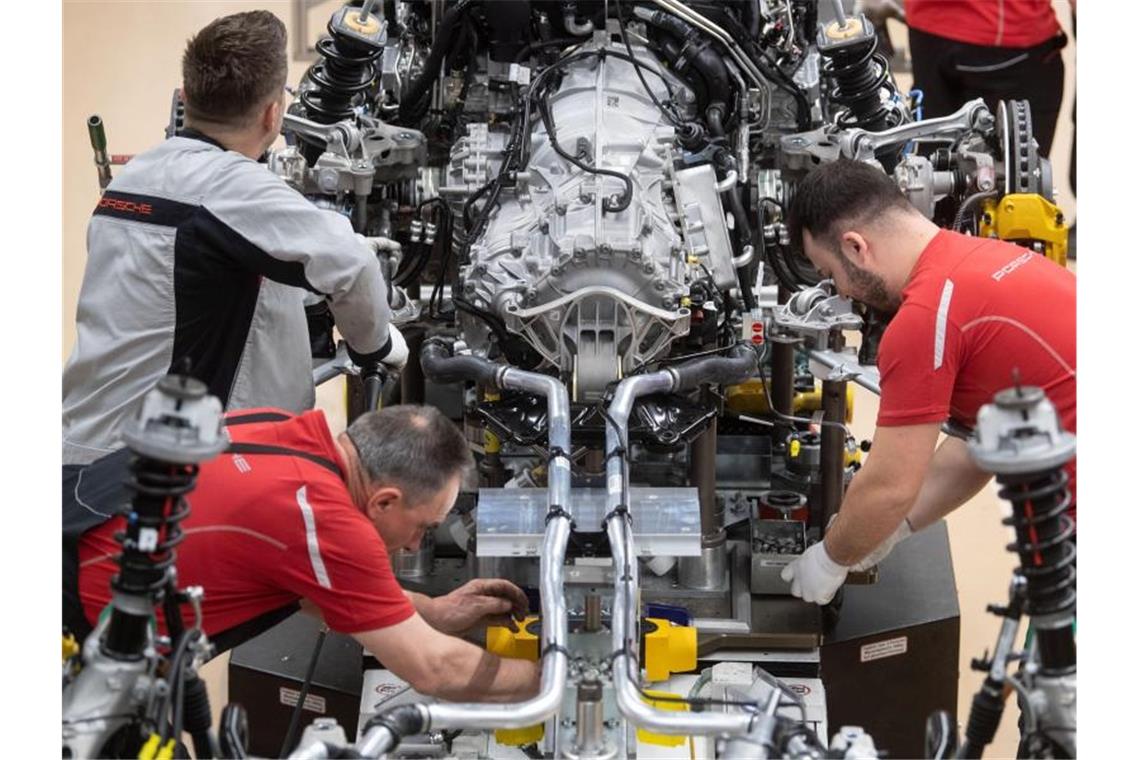 Greenpeace: Verkauf von Verbrenner-Autos bis 2028 stoppen Mitarbeiter der Porsche AG montieren im Hauptwerk den Verbrennungsmotor eines Porsche 911. Foto: Marijan Murat/dpa