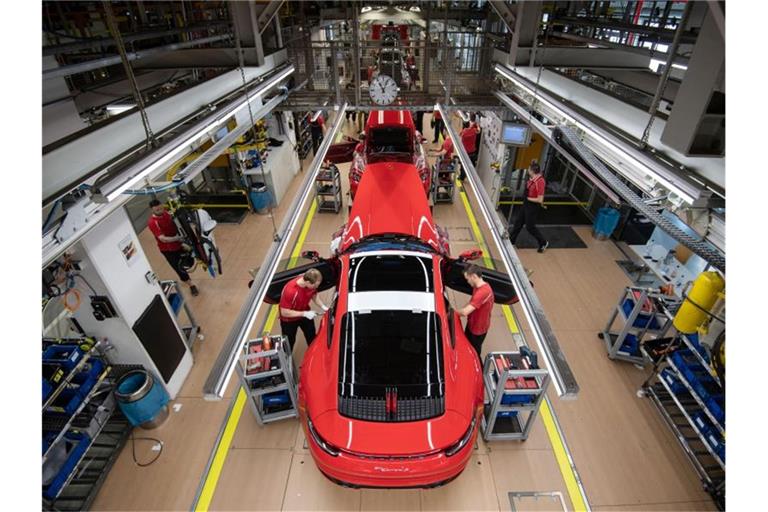 Mitarbeiter der Porsche AG montieren im Hauptwerk einen Porsche 911. Foto: Marijan Murat/dpa